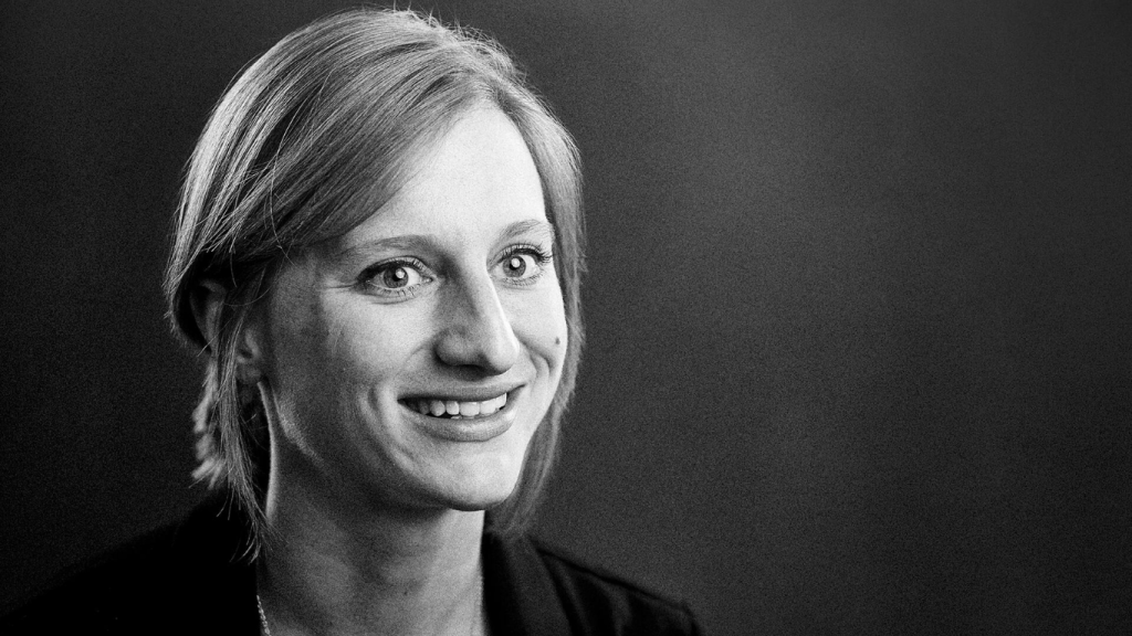 A professional black and white portrait of Stephanie McLaughlin smiling.